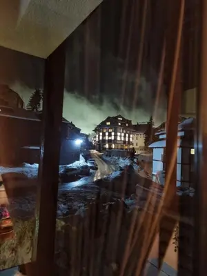 a window with a view of a city at night at Apartman Vrh,Kopaonik in Kopaonik