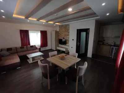 a living room with a table and a couch at Apartman K25 Milmari in Kopaonik