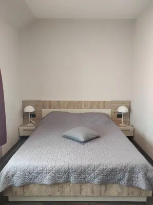 a bedroom with a bed with two lamps on both sides at Apartman K25 Milmari in Kopaonik