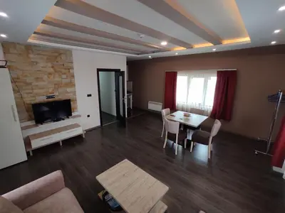 a living room with a table and chairs and a tv at Apartman K25 Milmari in Kopaonik
