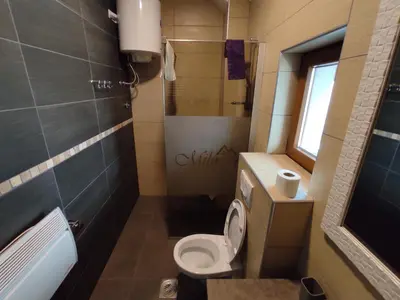 a small bathroom with a toilet and a window at Apartman K25 Milmari in Kopaonik