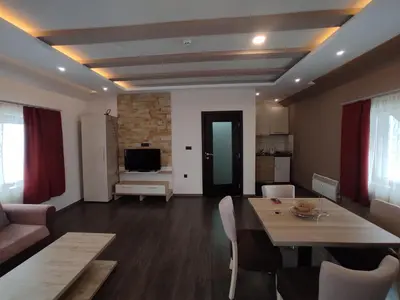 a living room with a table and a living room with a couch at Apartman K25 Milmari in Kopaonik