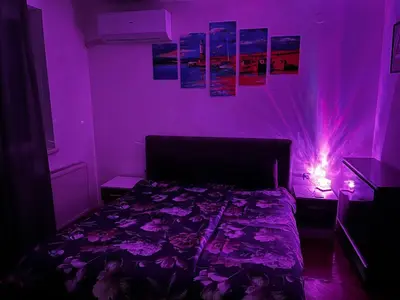 a purple bedroom with a bed and lights on the wall at Pufen Apartments - Nis in Niš