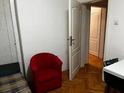 a red chair in a room with a door at Pufen Apartments - Nis in Niš