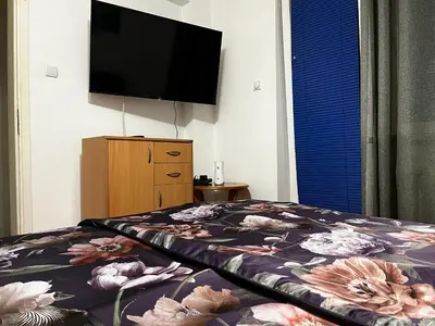 a bedroom with a bed with a flower patterned blanket at Pufen Apartments - Nis in Niš