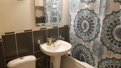 a bathroom with a sink and a toilet and a mirror at Pufen Apartments - Nis in Niš