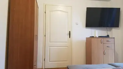 a white door in a room with a television at Pufen Apartments - Nis in Niš