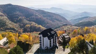 a building in the middle of a valley with mountains at Boggi Apartman, Kopaonik in Kopaonik