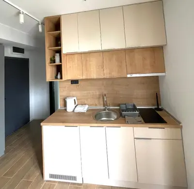 a kitchen with white cabinets and a sink at Boggi Apartman, Kopaonik in Kopaonik