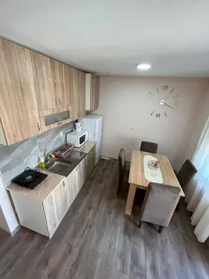 a small kitchen with a table and a sink at Apartman KVINS in Kruševac