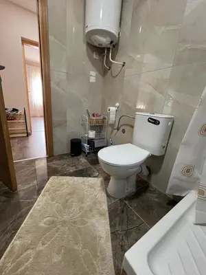 a bathroom with a toilet and a sink and a tub at Apartman KVINS in Kruševac