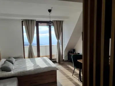 a bedroom with a bed and a large window at Apartman Snow Heaven Kopaonik in Kopaonik