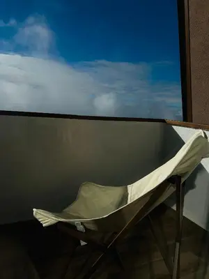 a white chair sitting on a balcony looking out a window at Apartman Snow Heaven Kopaonik in Kopaonik