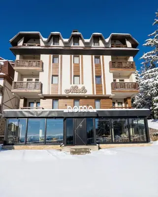 a hotel in the snow with a building at Nomakop5 in Kopaonik