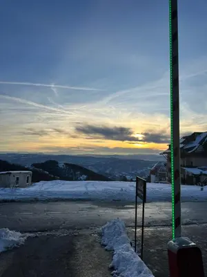 a sign in the snow with the sunset in the background at Nomakop5 in Kopaonik