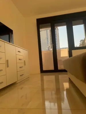 a living room with a couch and a large window at Best Deal Suite in Niš