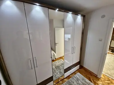 a large white wardrobe with a mirror in a room at Apartman Leskovac in Leskovac
