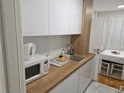 a kitchen counter with a microwave and a sink at Apartman Leskovac in Leskovac