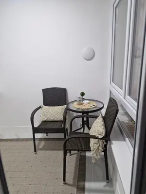 a table and chairs in a room with a window at Apartman Leskovac in Leskovac