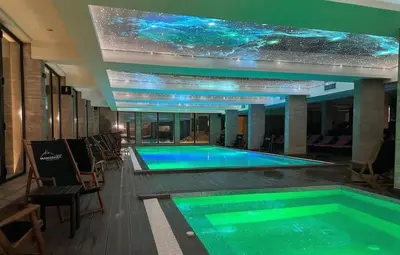 a swimming pool in a building with a star ceiling at Apartments Kos - Milmari Resort in Kopaonik