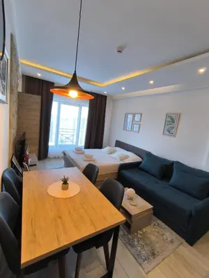 a living room with a blue couch and a table at Apartments Kos - Milmari Resort in Kopaonik