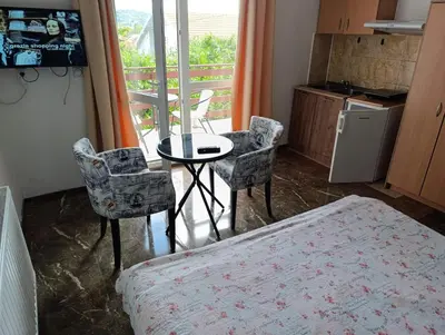a room with a bed and a table and chairs at Apartments Nebojša in Soko Banja