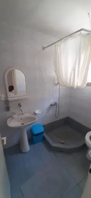 a white bathroom with a sink and a toilet at Apartments Nebojša in Soko Banja