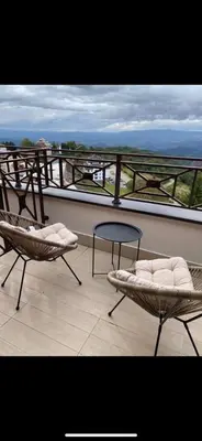 two chairs and a table on top of a balcony at Milmari kop in Raška