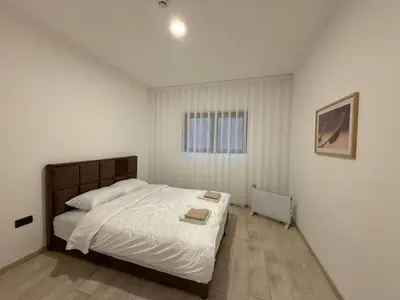 a bedroom with a bed with white sheets and a window at Milmari kop in Raška