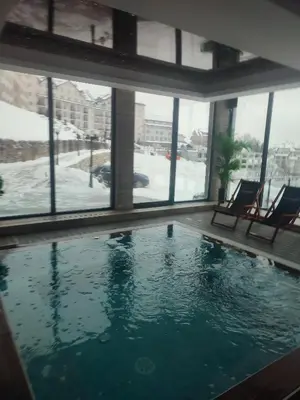 a swimming pool in a building with windows at Milmari kop in Raška