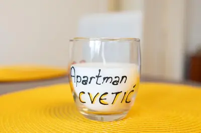 a glass of milk sitting on a yellow table at CVETIĆ apartman in Zaječar