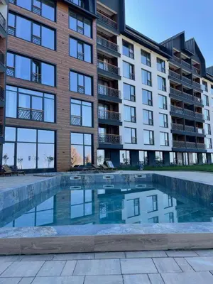 a building with a swimming pool in front of a building at Planinski kutak Residence Hill in Kopaonik