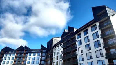 a row of apartment buildings against a cloudy sky at Planinski kutak Residence Hill in Kopaonik