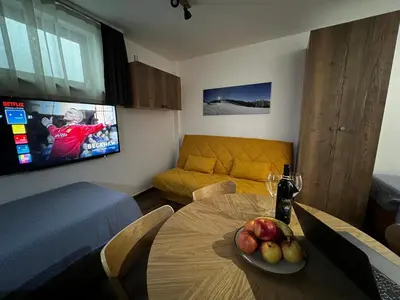a living room with a table with a plate of fruit on it at Z3 Studio in Kopaonik