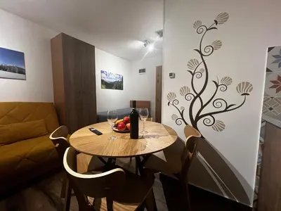 a dining room with a table and a couch at Z3 Studio in Kopaonik