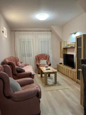 a living room with two chairs and a table at Apartman KVINS 1 in Kruševac