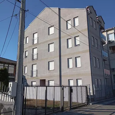 a tall building with a fence in front of it at Apartman KVINS 1 in Kruševac