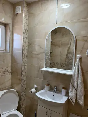 a bathroom with a sink and a toilet and a mirror at Apartman KVINS 1 in Kruševac