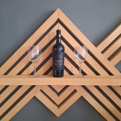 a bottle of wine on a wooden shelf with two wine glasses at Hera Kopaonik in Kopaonik