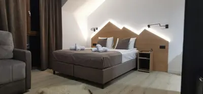 a bedroom with a bed with two stuffed animals on it at Vučja reka in Crni Vrh