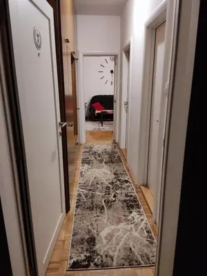 a hallway with a black and white rug at Apartman Trijumf in Vrnjačka Banja