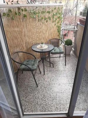 a patio with a table and chairs on a balcony at Apartman Trijumf in Vrnjačka Banja