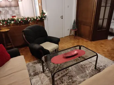 a living room with a glass coffee table and christmas decorations at Apartman Trijumf in Vrnjačka Banja