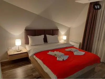 a bedroom with a large bed with two towels on it at Milmari GOGA APARTMAN in Kopaonik