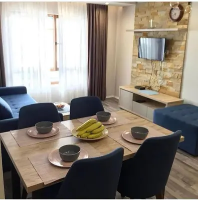 a dining room table with chairs and bananas on it at Milmari GOGA APARTMAN in Kopaonik