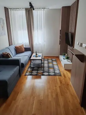 a living room with a couch and a table at Brzece lux apartman in Brzeće