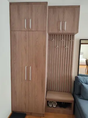 a bedroom with wooden cabinets and a bed at Brzece lux apartman in Brzeće