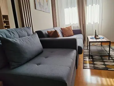 a living room with a couch and a table at Brzece lux apartman in Brzeće