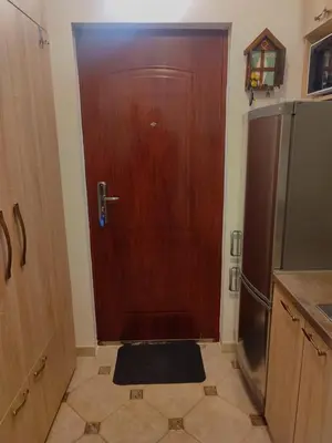 a kitchen with a wooden door and a refrigerator at Kopaonik apartman Miklušev in Kopaonik