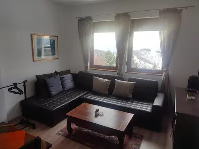 a living room with a couch and a coffee table at Kopaonik apartman Miklušev in Kopaonik